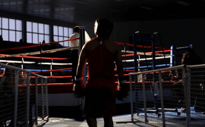 A silhouetted boxer entering the ring.