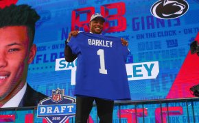Saquon Barkley holding his Giants jersey after being drafted at the 2018 NFL Draft