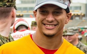 Patrick Mahomes smiling for the camera in a Chiefs visor.