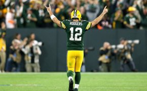 Aaron Rodgers with his arms in the air celebrating