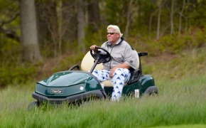John Daly drives in a golf cart.