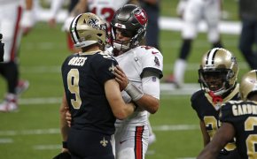 New Orleans Saints quarterback Drew Brees and Tampa Bay Buccaneers quarterback Tom Brady hugging on the field after a game.