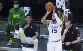 Seton Hall's Takal Molson taking a jump shot in a game in front of the Oregon bench.