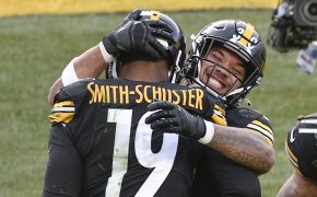 Pittsburgh Steelers wide receiver JuJu Smith-Schuster celebrating on the field by giving running back James Conner a hug.
