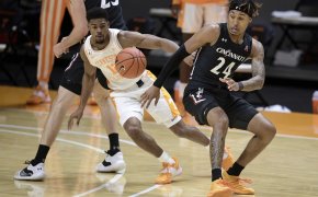Cincinnati men's basketball guard Jeremiah Davenport losing control of the ball during a game. Tennessee guard Victor Bailey Jr. is attempting to gain possession of it..