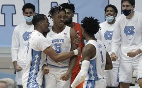 North Carolina men's basketball player Garrison Brooks celebrating with teammates during a NCAA game.