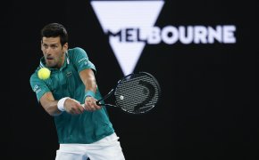 Novak Djokovic hitting a backhand shot in return during a Australian Open match.