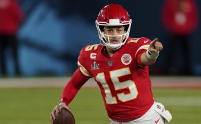 Patrick Mahomes pointing while on the run with football in right hand