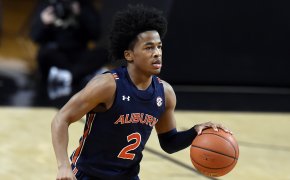 Auburn guard Sharife Cooper dribbling the ball in the middle of a NCAA men's basketball game.