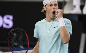 Denis Shapovalov reacting with a fist pump after winning a point during a tennis match.