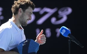 Aslan Karatsev being interviewed after a win during the Australian Open. He is giving a thumbs up and smiling.