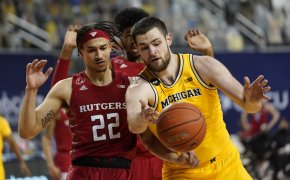 Rutgers guard Caleb McConnell and Michigan Wolverines center Hunter Dickinson battling for a loose ball during a NCAA men's basketball game.