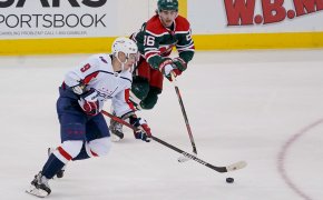 New Jersey Devils center Jack Hughes playing defense against the Washington Capitals during a NHL game.