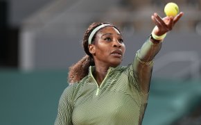 Serena Williams throwing the ball up to hit a serve during a match at the 2021 French Open.