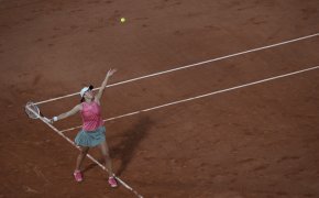 A wide shot of Iga Swiatek serving during a match at the 2021 French Open.