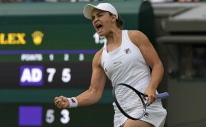 Ashleigh Barty celebrating with a fist pump after winning a match at Wimbledon.