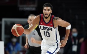 Jayson Tatum dribbling the ball up thee court during an Olympic basketball game.
