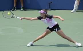 Elise Mertens stretching to return a forehand during a tennis match in San Jose.