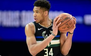 Giannis Antetokounmpo holding ball up near left ear with two hands