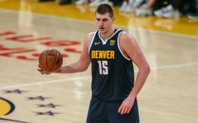 Nikola Jokic holding ball with right hand at top of the key