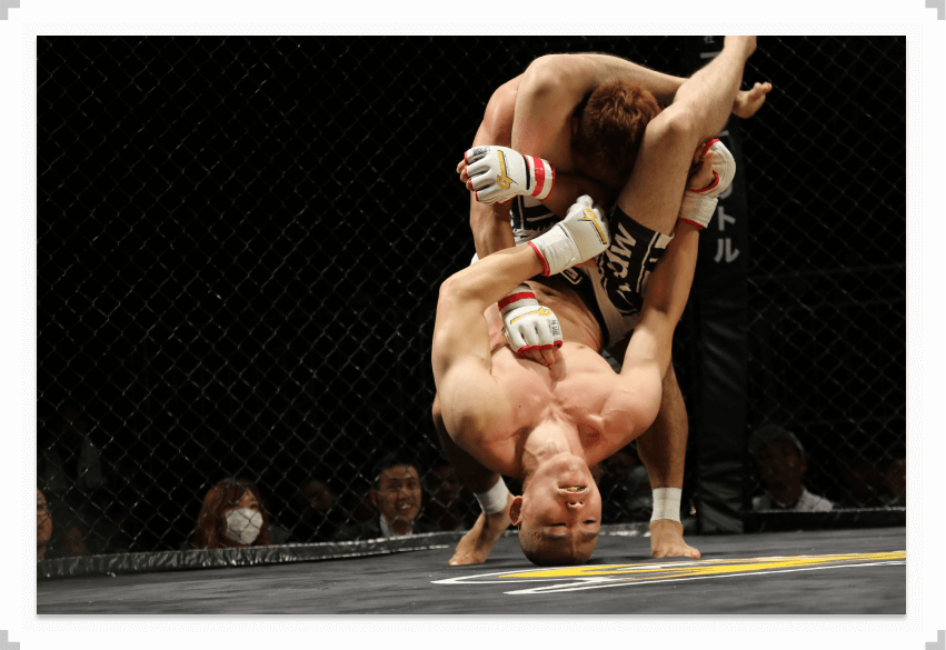 Two MMA fighters grappling during a fight