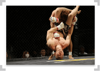 Two MMA fighters grappling during a fight
