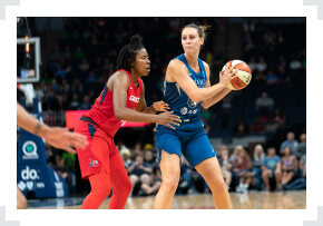 Minnesota Lynx player with ball in hands defended by opponent