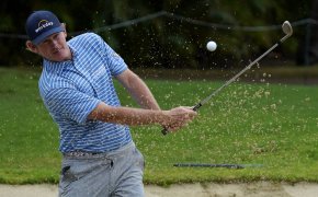 Brandt Snedeker hitting a ball out of a bunker during a golf tournament.