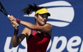 Emma Raducanu hitting a return shot during a tennis match at the US Open.