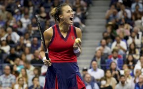 Aryna Sabalenka reacting after winning a point during a tennis match.