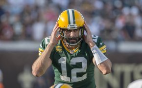 Aaron Rodgers holding hands to helmet while calling out play