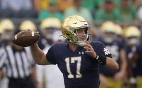 Notre Dame quarterback Jack Coan throwing the ball during a college football game.