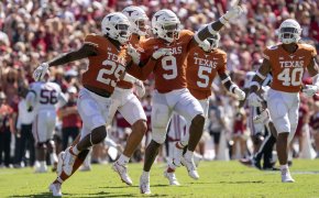 Texas players celebrating after an interception during a college football game.
