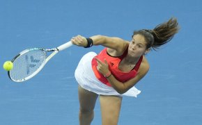 Daria Kasatkina serving the ball during a tennis match.