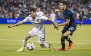 Real Salt Lake defender Aaron Herrera gains control of the ball over Sporting Kansas City forward Daniel Salloi during the first half of a soccer match.