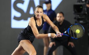 Karolina Pliskova hitting a return shot during a tennis match at the WTA Finals.