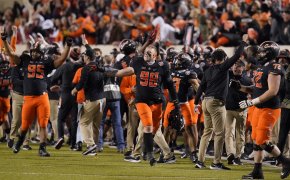 Oklahoma State players celebrating on the field during a football game.