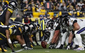 The Baltimore Ravens and the Pittsburgh Steelers lining up at the line of scrimmage.