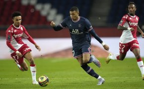 PSG's Kylian Mbappe fighting for the ball against Monaco's Sofiane Diop during a soccer match.