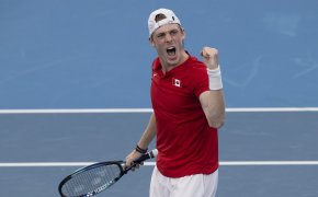 Denis Shapovalov reacting with a fist pump during a tennis match.