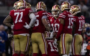 San Francisco 49ers quarterback Jimmy Garoppolo huddling around his teammates.