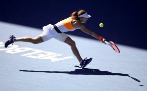 Alize Cornet stretching to get to a ball during a tennis match at the Australian Open.