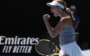 Danielle Collins reacting with a fist pump and a yell after winning a point during a tennis match at the Australian Open.