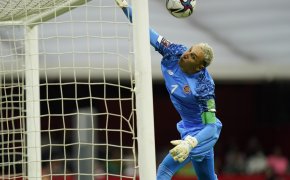 Costa Rica's goalkeeper Keylor Navas diving to save a free kick during a soccer match.