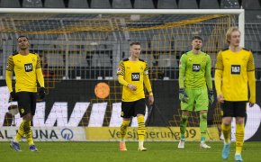 Dortmund players looking disappointed after being scored on during a match.