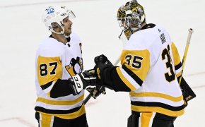Pittsburg Penguins goaltender Tristan Jarry celebrating with Sidney Crosby on the ice after winning the game.