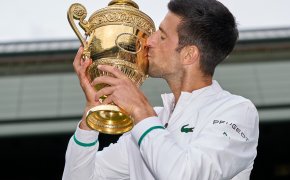Novak Djokovic kissing Wimbledon trophy