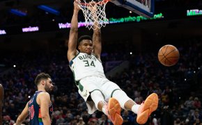 Giannis Antetokounmpo hanging on rim after dunking