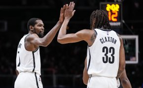 Kevin Durant and Nic Claxton high fiving during a game.