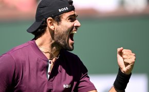 Matteo Berrettini celebrating with a fist pump during a tennis match.